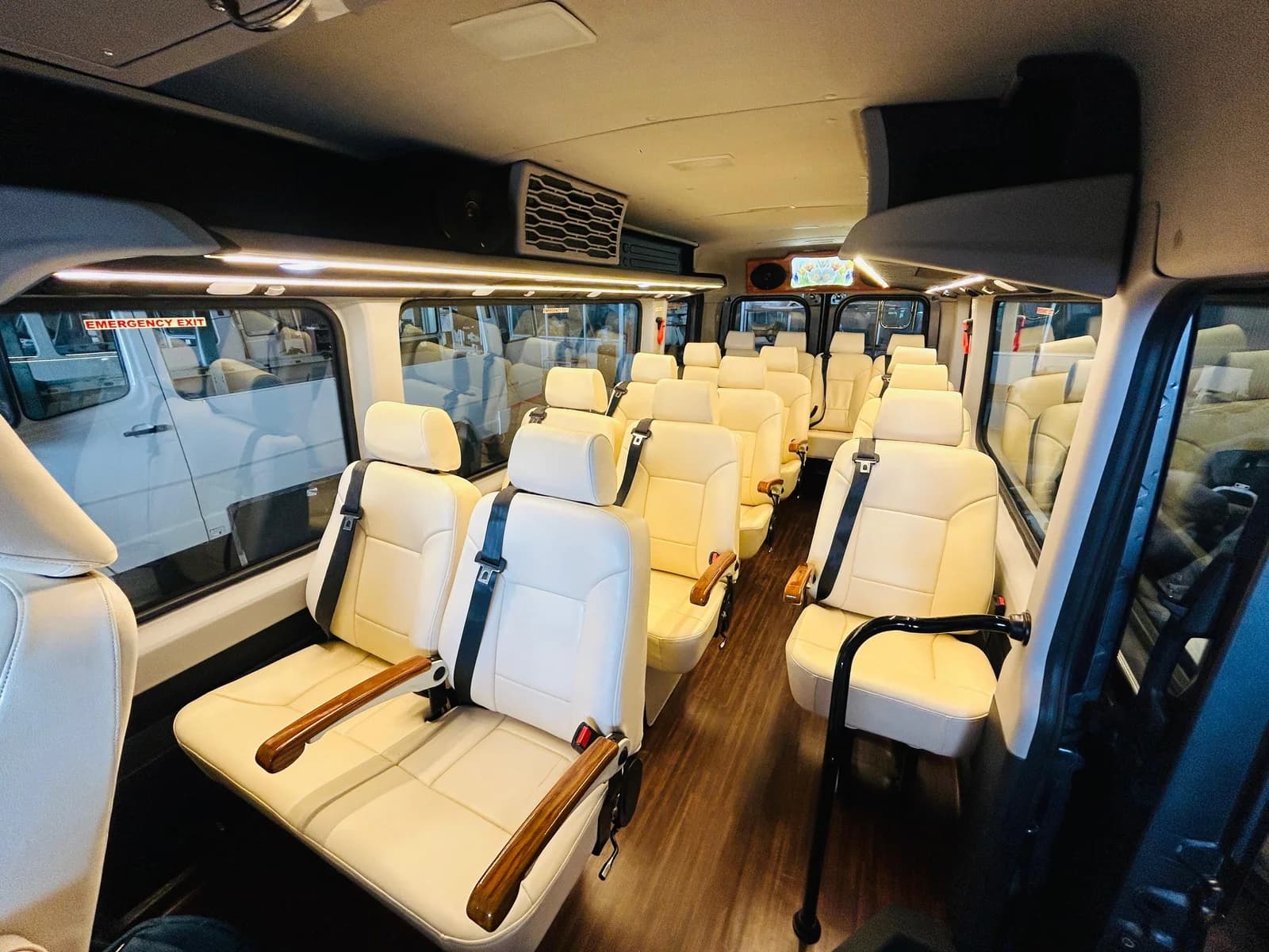 A light passenger vehicle interior with individual seats, seat belts and a central aisle