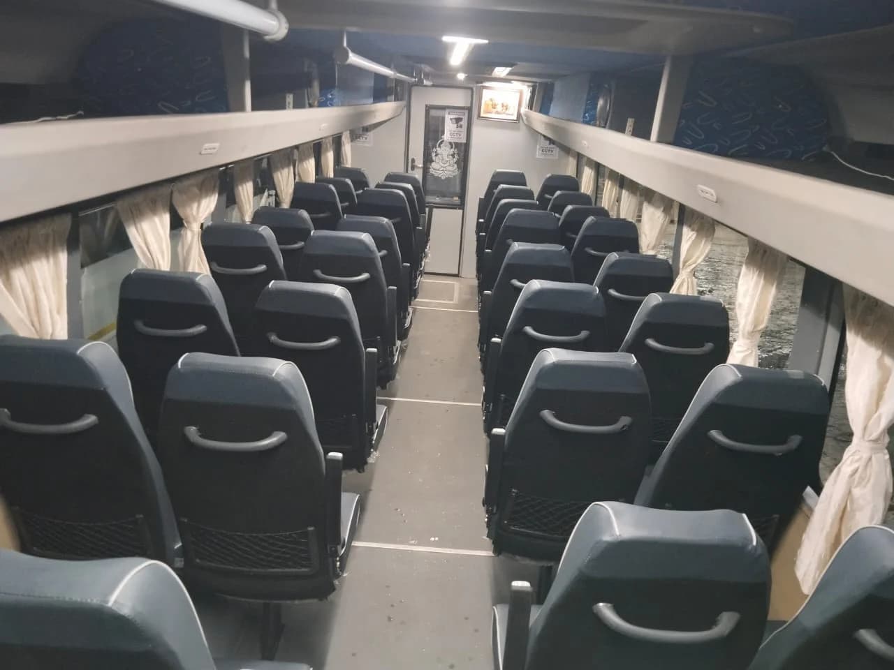 Passenger seating and central aisle inside a Jesus Travels vehicle
